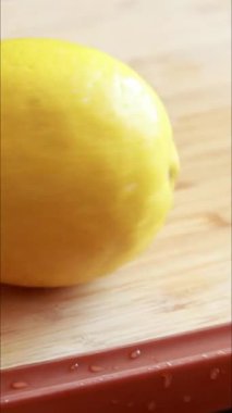 Tahta üzerinde taze limon dilimleme dikey videoyu kapat