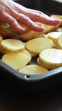 Tepside dilimlenmiş çiğ patates, dikey videoyu pişirmeye hazır.