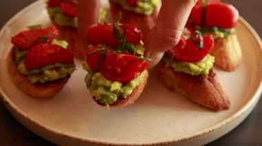 Avokado püresi ve fırında kiraz domatesli crostini stok videosunu kapat