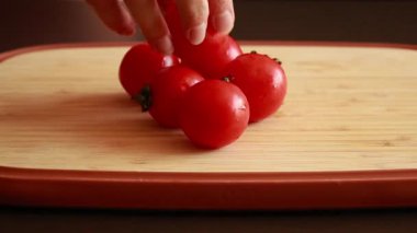 Ahşap kesim tahtasındaki bir grup kiraz domatesi stok videosunu kapatın
