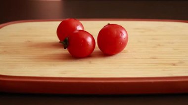 Ahşap kesim tahtasındaki bir grup kiraz domatesi stok videosunu kapatın