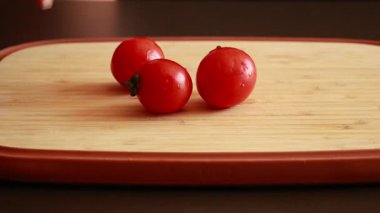 Ahşap kesim tahtasındaki bir grup kiraz domatesi stok videosunu kapatın