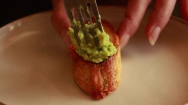  Kremalı avokado ve kızarmış vişneli domatesle kaplanmış crostini, zarif bir parti yemeği olarak servis ediliyor.