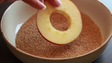 Kahverengi şeker ve tarçınla kaplanmış taze elma dilimlerinin yakın plan videosu. Sonbahar tarifleri, tatil tatlısı, turta yapmak ve sıcak yemek sahneleri için mükemmel.