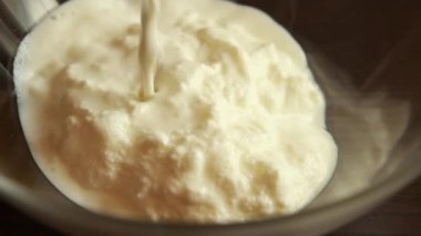 Sütlü yoğurt ve yulafları cam kasede karıştırıyorum. Stok videosunu kapat.