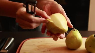 Tahta bir kesme tahtasının üzerinde taze armutların dilimlendiği yakın plan bir video. Yemek pişirme, pişirme hazırlığı, sağlıklı tarifler ve mutfak içeriği için mükemmel.