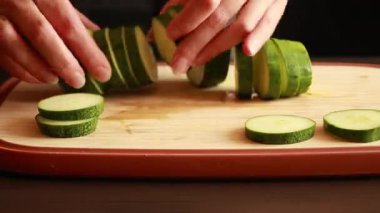 Tahta kesme tahtasındaki taze salatalığı dilimle. Stok videosunu kapat.