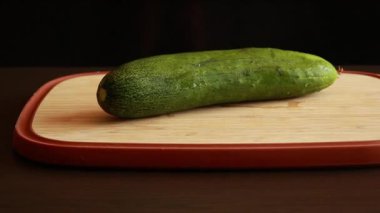 Tahta kesme tahtasındaki taze salatalığı dilimle. Stok videosunu kapat.