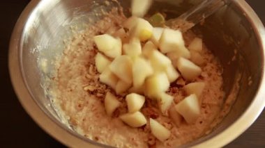 Yulaf ezmesini doğranmış armutla karıştırmak. Bir kasede pişirmek. Yakın çekim videosu.