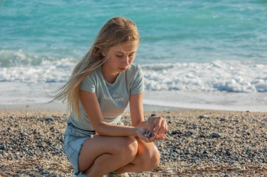 Sahilde eğlenen 11 yaşındaki gülümseyen bir kızın yakın çekim fotoğrafı. Yaz, tatil ve tasasız çocukluk teması için mükemmel.
