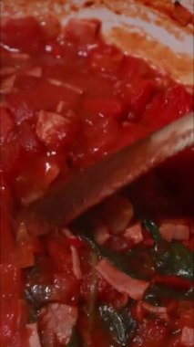 Shakshuka tarifi için pişirilen yumurta ve domateslerin dikey görüntüleri