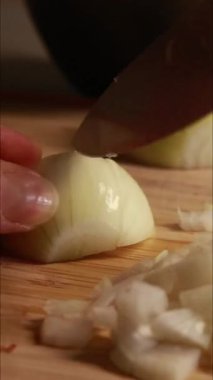 Sarı soğan doğrayan kadın dikey mutfak videosunu kapat
