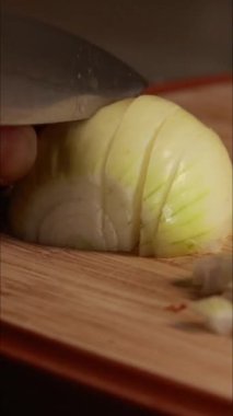 Sarı soğan doğrayan kadın dikey mutfak videosunu kapat