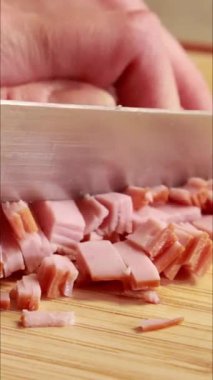 Kadın elleri kesme tahtasının üzerinde jambon hazırlıyor ve doğruyor.