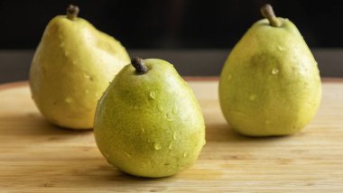 Kırsal ahşap yüzeyde üç organik armut.