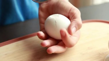 Kaşıkla haşlanmış yumurtayı kırmaya yakın.