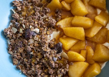 Sıcak sonbahar kahvaltı kasesi Yunan yoğurdu, karamelli elma.