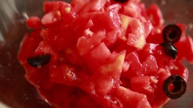 Cam kasede doğranmış domatesle siyah zeytinleri karıştırıyorum.