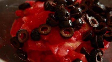 Cam kasede doğranmış domatesle siyah zeytinleri karıştırıyorum.