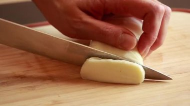 Kadınlar taze mozzarella peynirini tahta kesme tahtasıyla dilimliyor.