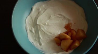 Yunan yoğurdu ve karamelize elma dilimleriyle sonbahar kahvaltısı kasesi.