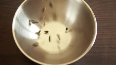 Ağır çekimde kabak tohumlarının kaseye düşüşünü yakından izle.