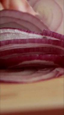 Kesme tahtasında taze kırmızı soğan dilimleniyor