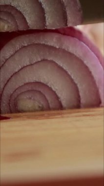 Kesme tahtasında taze kırmızı soğan dilimleniyor