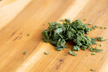 Tahta kesme tahtasında taze adaçayı dilimlenmiş.