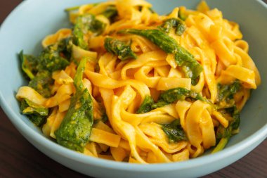 Lezzetli kabaklı tagliatelle makarnası ıspanaklı, sonbahar sofrası mavi kasede servis ediliyor.