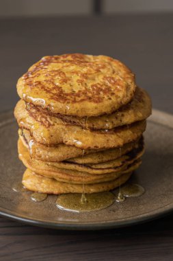 Üzerinde şurup olan kabak kabaklı krep yığınının yakın plan fotoğrafı.