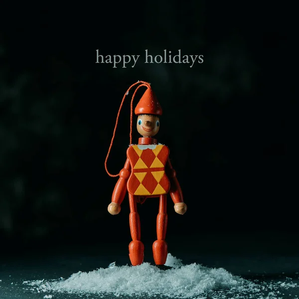 Der Text Frohe Feiertage Und Ein Christbaumschmuck Form Einer Harlekinschnurpuppe — Stockfoto