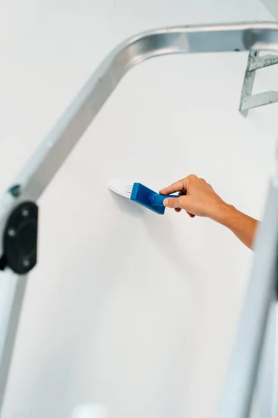 Young Caucasian Man Spreads Some Glue Brush White Wall Attach — Stock Photo, Image