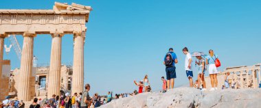 Atina, Yunanistan - 30 Ağustos 2022: Yunanistan 'daki Atina Akropolünü, ünlü Parthenon' un kalıntılarına panoramik bir formatta ziyaret eden bir turist topluluğu