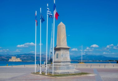 a view of the Monument for the Morea Expedition, in Philellinon Square, in Napflio, Greece, and Bourtzi castle in the sea in the background