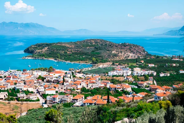 a view over Palaia Epidavros, in Greece, and the small theater of the Ancient City of Epidaurus in the background on the right