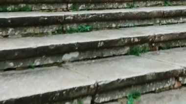 the camera is climbing the old and weathered stairs of an outdoors staircase in Europe on autumn or winter