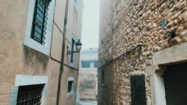 walking by a street of the old town of Girona, in Spain, on a winter day with some frog
