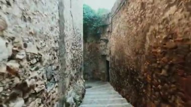 hyperlapse video of someone walking by the streets of the old town of Girona, in Spain, on autumn or winter