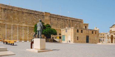 a view over Castille Square in Valletta, Malta, with Saint James Cavalier in the background, on a summer day, in a panoramic format to use as web banner or header
