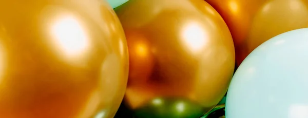 closeup of some elegant golden balloons as a decoration for a birthday party, or a bridal shower or any other party, in a panoramic format to use as web banner or header
