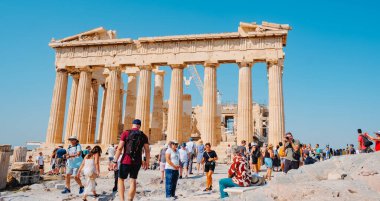 Athens, Greece - August 30, 2022: A crowd of visitors walking by the Acropolis of Athens, Greece, in front of the remains of the famous Parthenon,