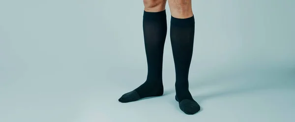 Closeup Man Standing White Background Wearing Compression Socks Panoramic Format — Stock Photo, Image