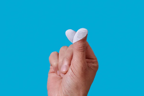 Человек Формирует Сердце Белыми Пальцами Голубом Фоне — стоковое фото