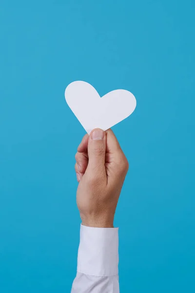Man Som Håller Ett Vitt Hjärta Handen Mot Blå Bakgrund — Stockfoto