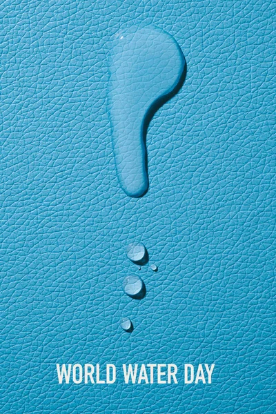青いテクスチャの表面とテキストの世界の水の日に水のいくつかの滴の高角度ビュー — ストック写真