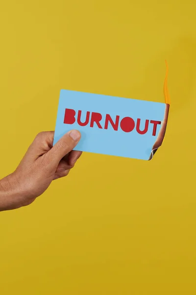 Man Holds Blue Sign Fire Text Burnout Front Yellow Background — Stock Photo, Image