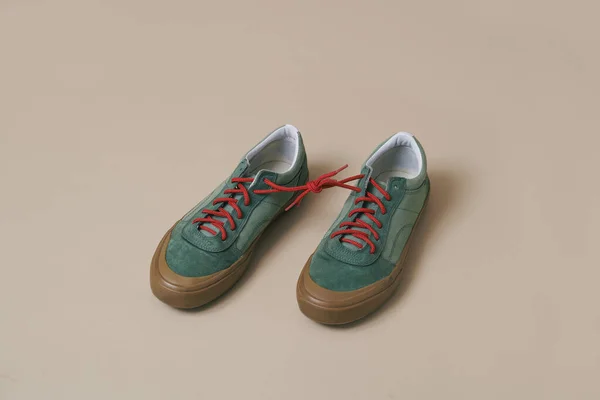 Pair Green Sneakers Its Shoelaces Tied Together Pale Brown Background — Stock Photo, Image