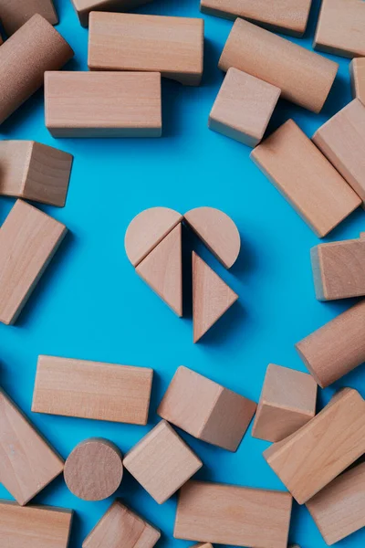 Hochwinkelaufnahme Einiger Holzbausteine Die Ein Herz Auf Blauem Hintergrund Bilden — Stockfoto