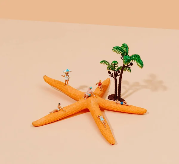 Miniaturní Lidé Plavkách Odpočívající Hvězdici Vedle Několika Miniaturních Palem Světle — Stock fotografie